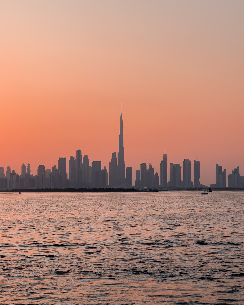 Dubai skyline and Burj Khalifa above the water at sunset